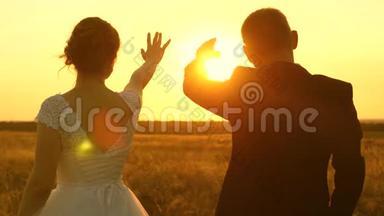 一男一女在<strong>夕阳</strong>下用手秀出一颗心。浪漫之旅中的<strong>恋人</strong>。团队合作
